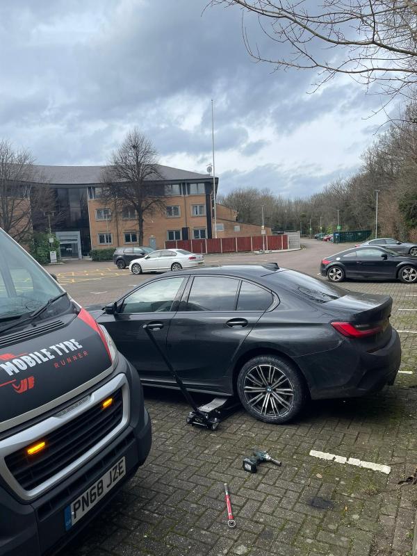BMW on a trolley jack in an office car park with the Mobile Tyre Runner van alongside